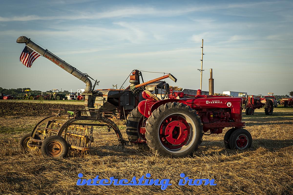 Farmall M with a hay rake.