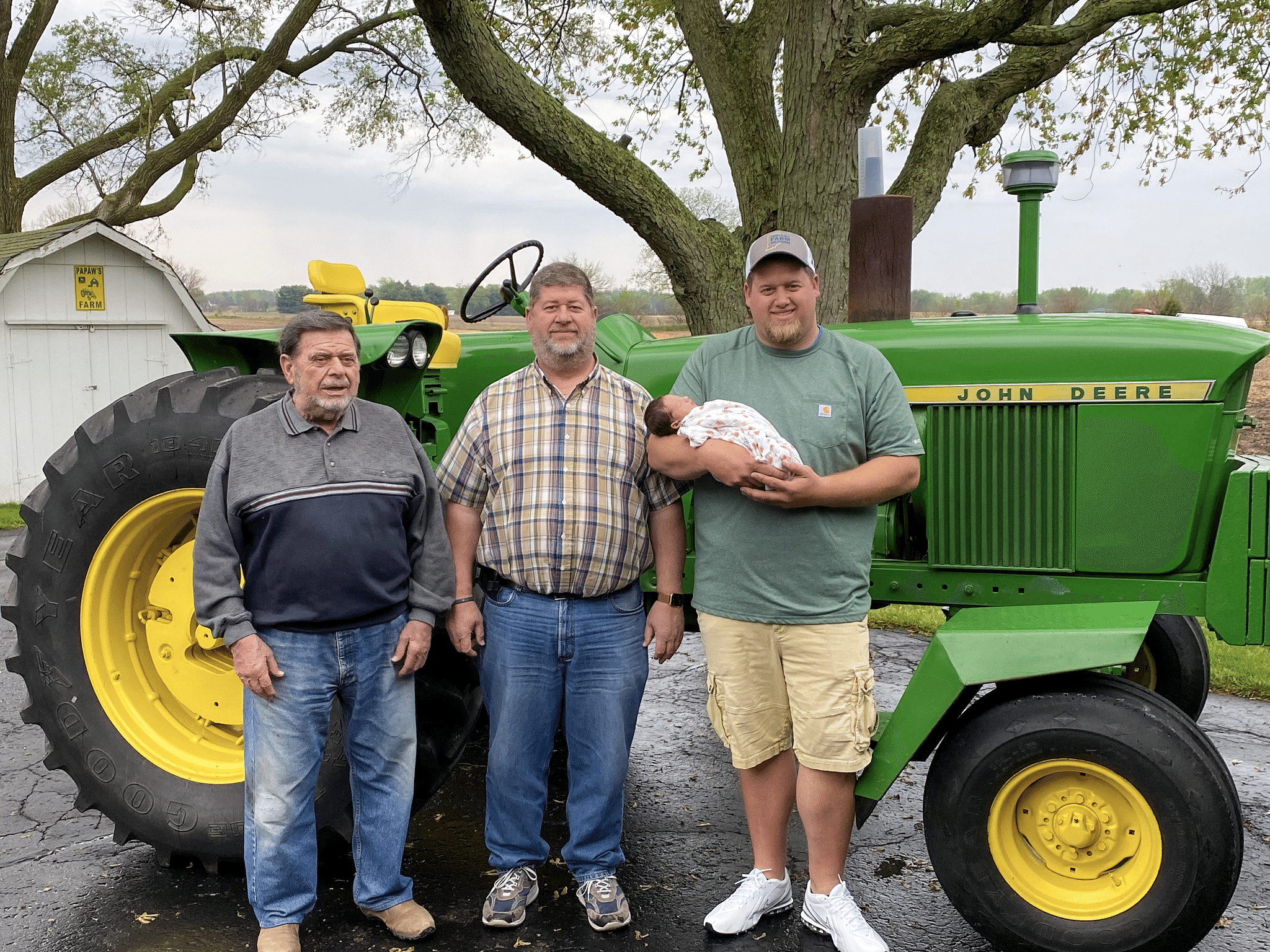 four generations in front of grandpa's tractor
