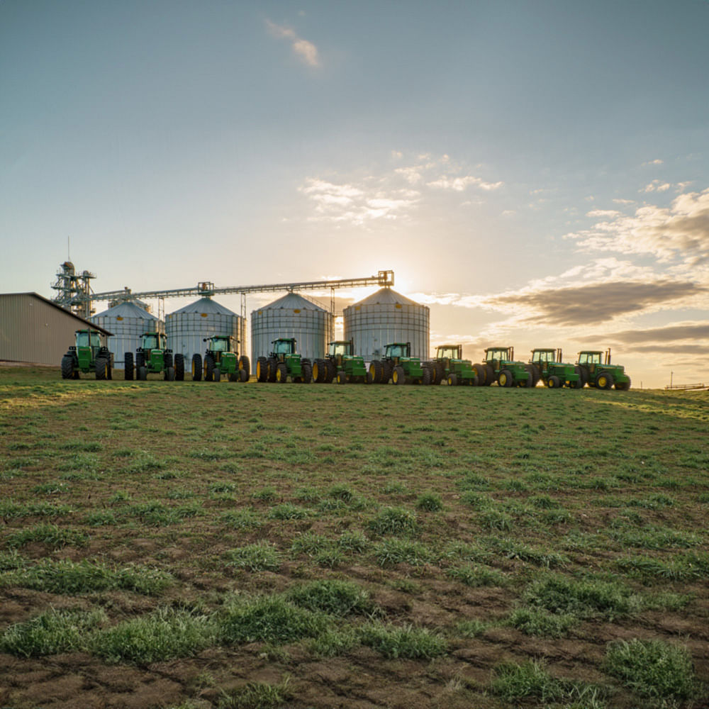 55-Series John Deere tractor collection at sunset