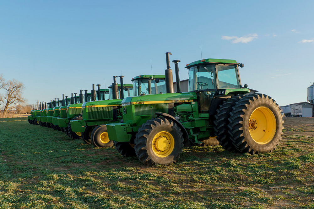 55-Series John Deere SoundGard tractors lined up at sunset
